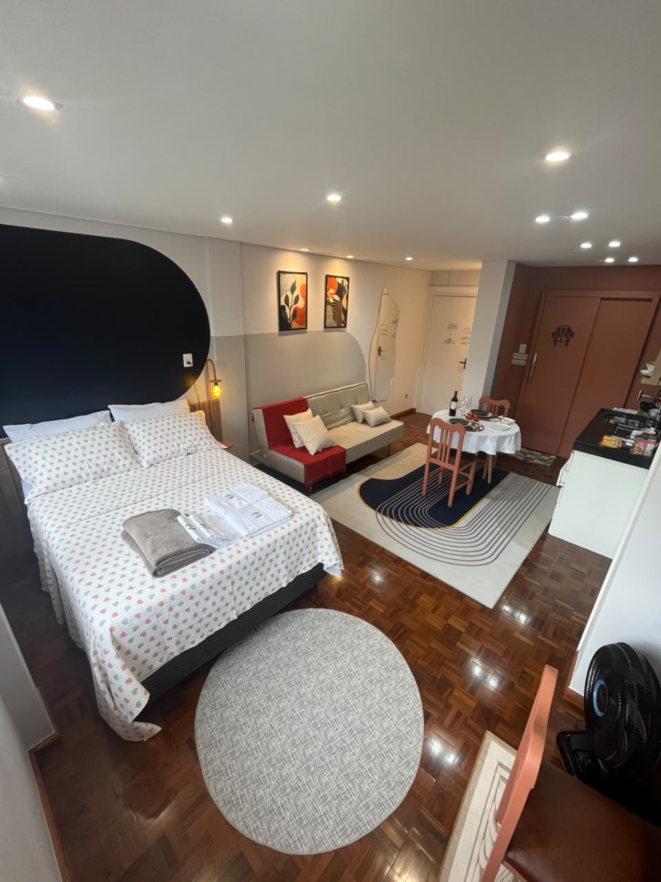 Studio da Suíte Horto I com cama de casal, sofá-cama e mesa de jantar