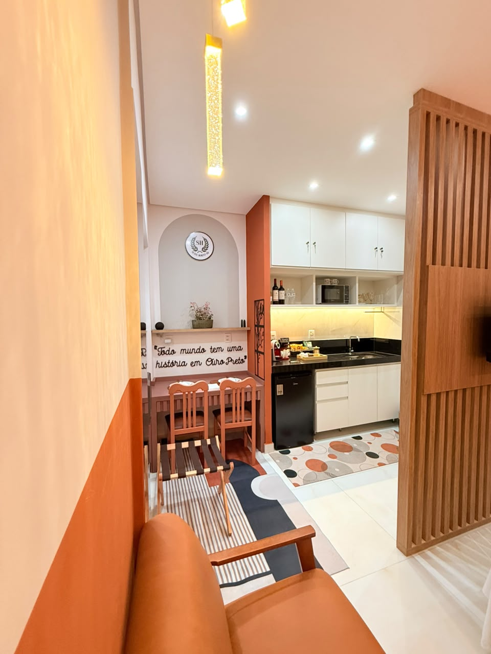 Suíte Horto III com cozinha gourmet, mesa posta e a frase Todo mundo tem uma história em Ouro Preto