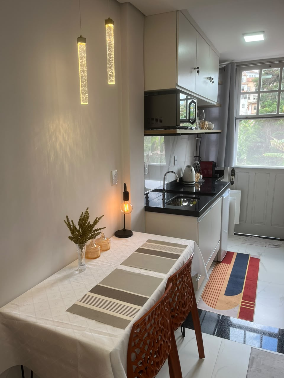 Cozinha gourmet e mesa de jantar da Suíte Horto II com vista para a janela