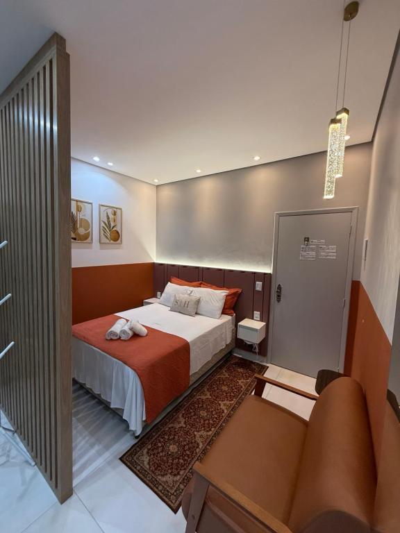 Interior da suíte com cama e sofá terracota